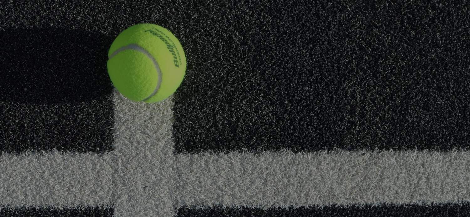 A padel ball resting on the court line